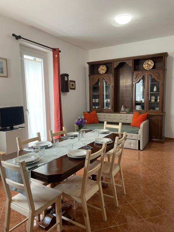 ein Esszimmer mit Tisch und Stühlen und einer Couch in der Unterkunft Bnbook Quadrilocale Italia in Rho