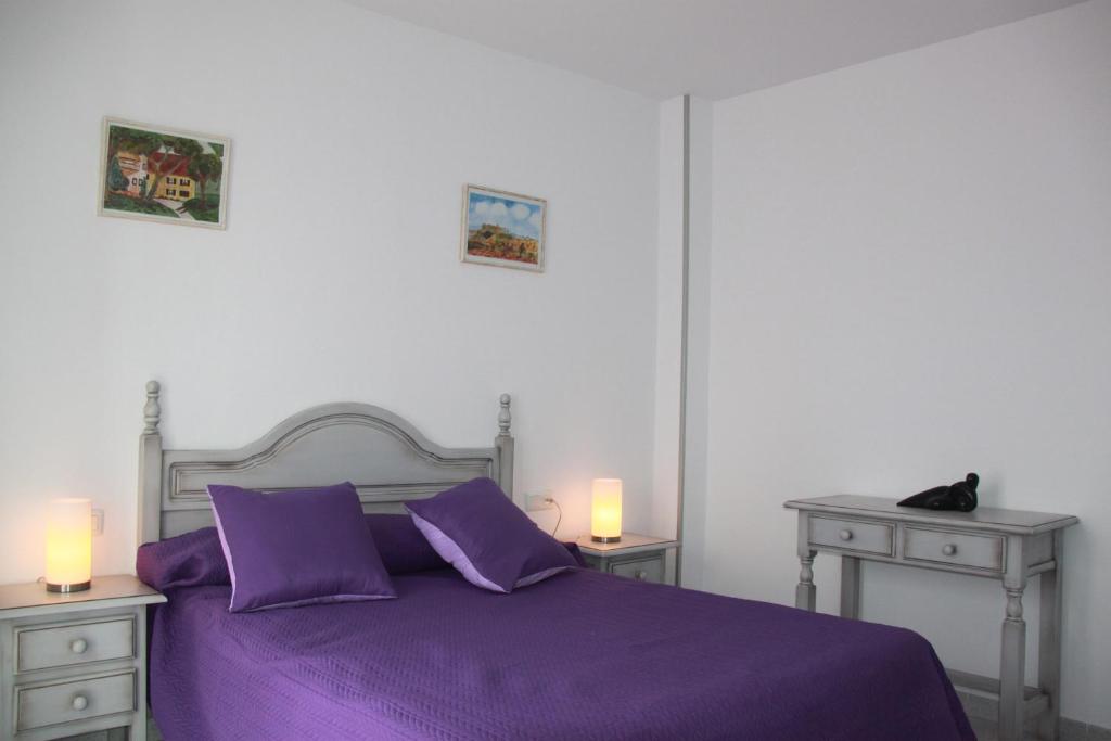 1 dormitorio con 1 cama de color púrpura y 2 mesitas de noche en Apartamentos El Yunque- Solo Familias, en Conil de la Frontera