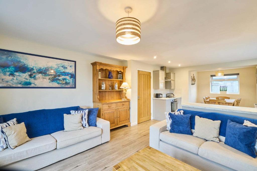 a living room with two white couches and a kitchen at Host & Stay - Kittling Nook in Bamburgh