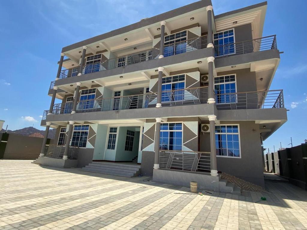 un gran edificio blanco con balcones en la parte superior. en RENA Apartments, en Dodoma