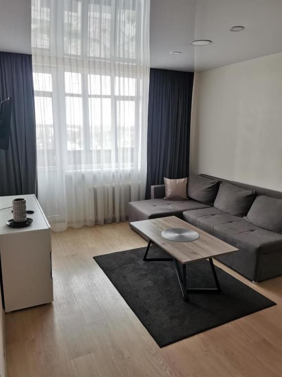 a living room with a couch and a coffee table at Lauros 1 & R Apartamentai in Panevėžys