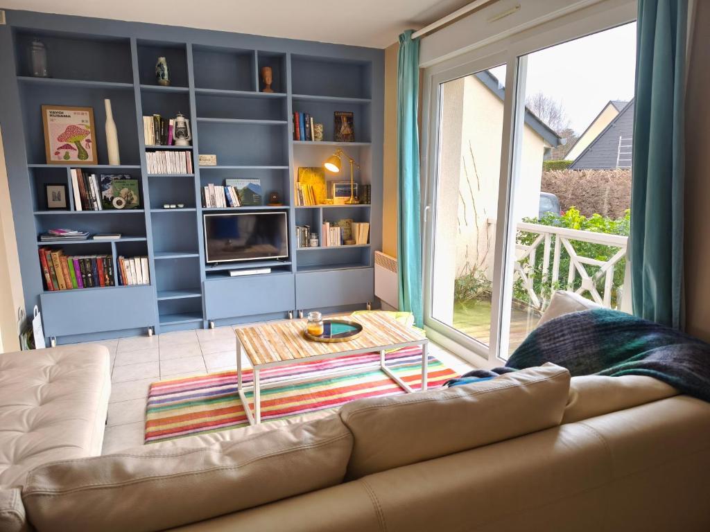 un salon avec un canapé et une grande fenêtre dans l'établissement L'écume des Jours, à Bréville-sur-Mer