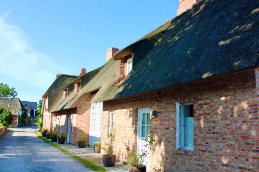 eine Reihe von Backsteinhäusern mit einer Straße in der Unterkunft Haus Boldix Whg 6 St Barth in Boldixum