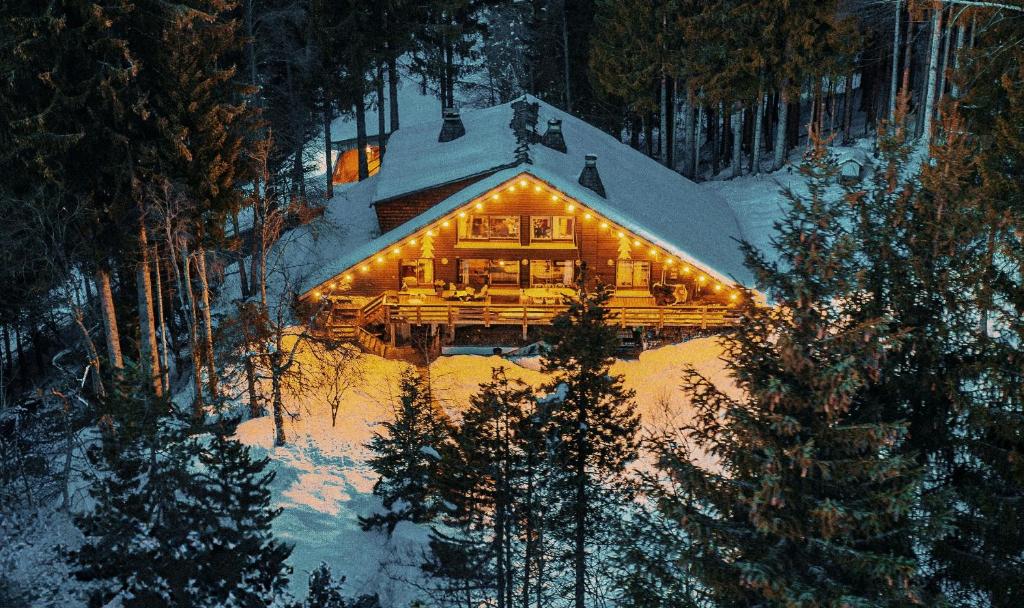 une cabane en rondins dans la neige éclairée dans l'établissement Large peaceful chalet for mountain adventures! Perfect for Flégère and Grand Montet skiing, à Chamonix-Mont-Blanc