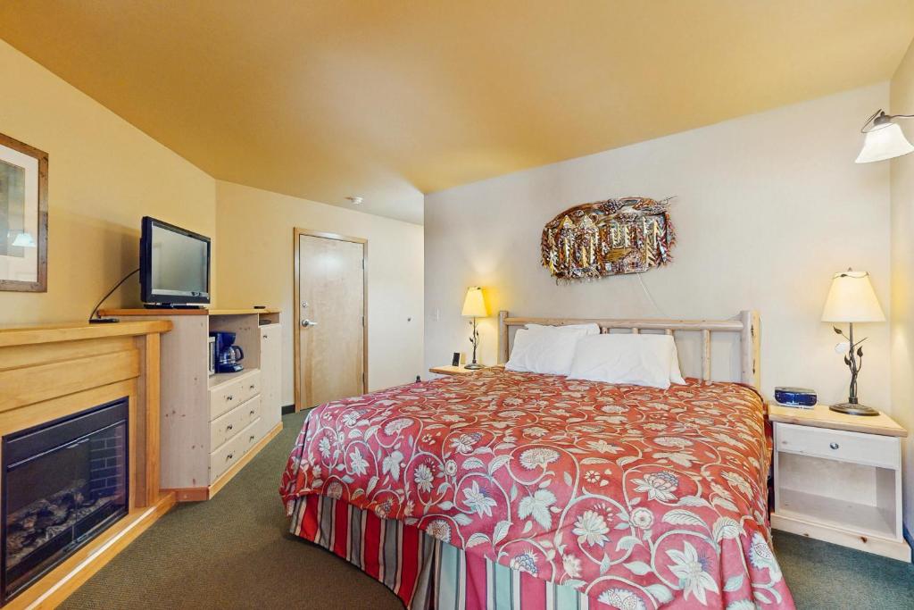 ein Hotelzimmer mit einem Bett und einem Flachbildfernseher in der Unterkunft Icicle Village Resort Condo #408 in Leavenworth