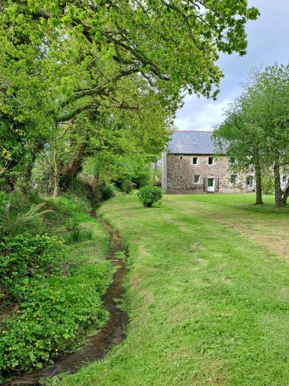 a stone house with a stream in the yard at Environnement calme et reposant - Côtes-d'Armor in Ploëzal