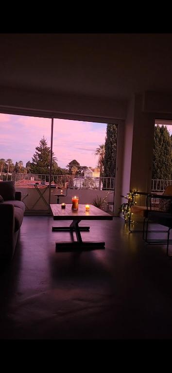 un salon avec une table et une grande fenêtre dans l'établissement Beach house, à Cannes