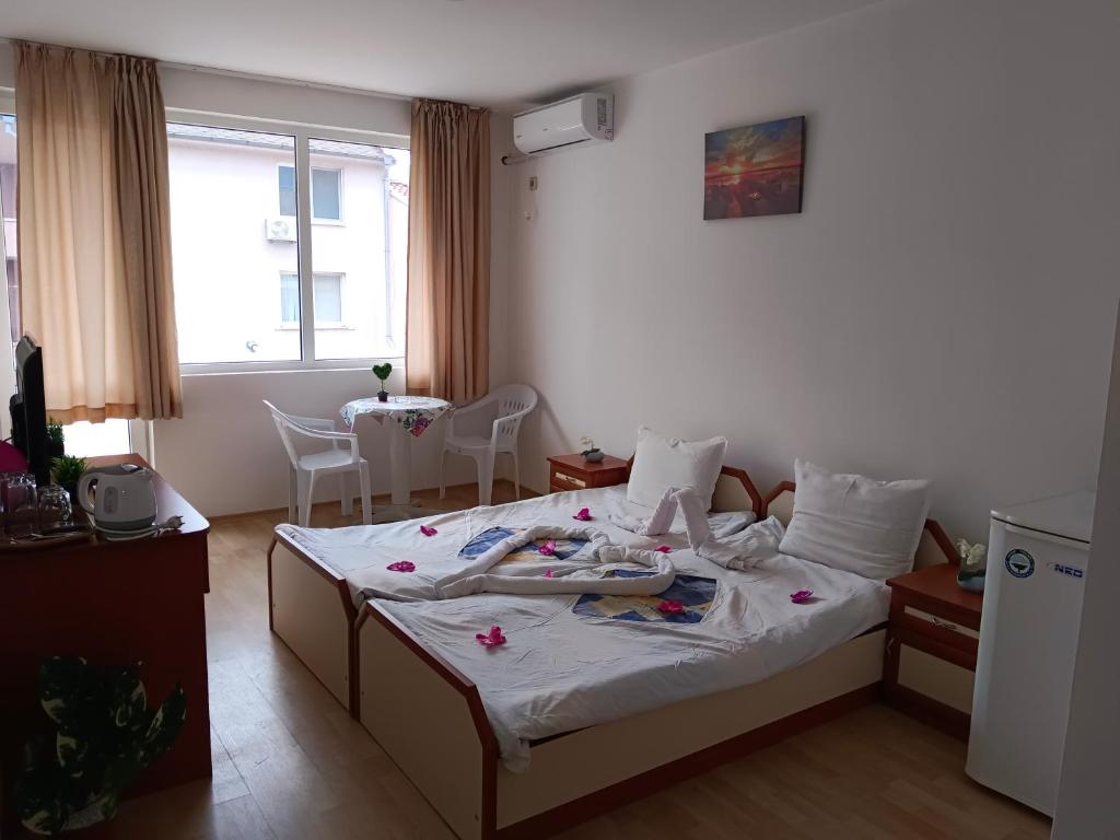 a bedroom with a bed with clothes on it at Стаи за гости Ники in Nesebar
