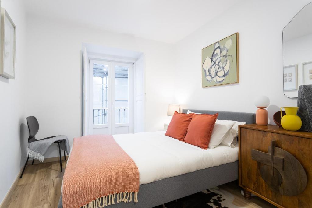 a bedroom with a bed with orange pillows on it at Cozy and confy First Floor, Ace location, 2 Bedrooms in Lisbon
