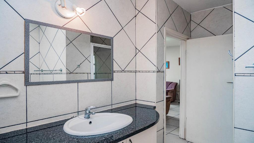 a bathroom with a sink and a mirror at Peacehaven Beachfront Property - Scottburgh KZN in Scottburgh