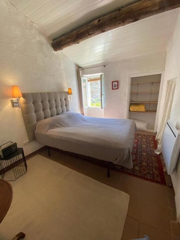 une chambre avec un grand lit et une fenêtre dans l'établissement Joli T2 in Cap Corse, à Ersa