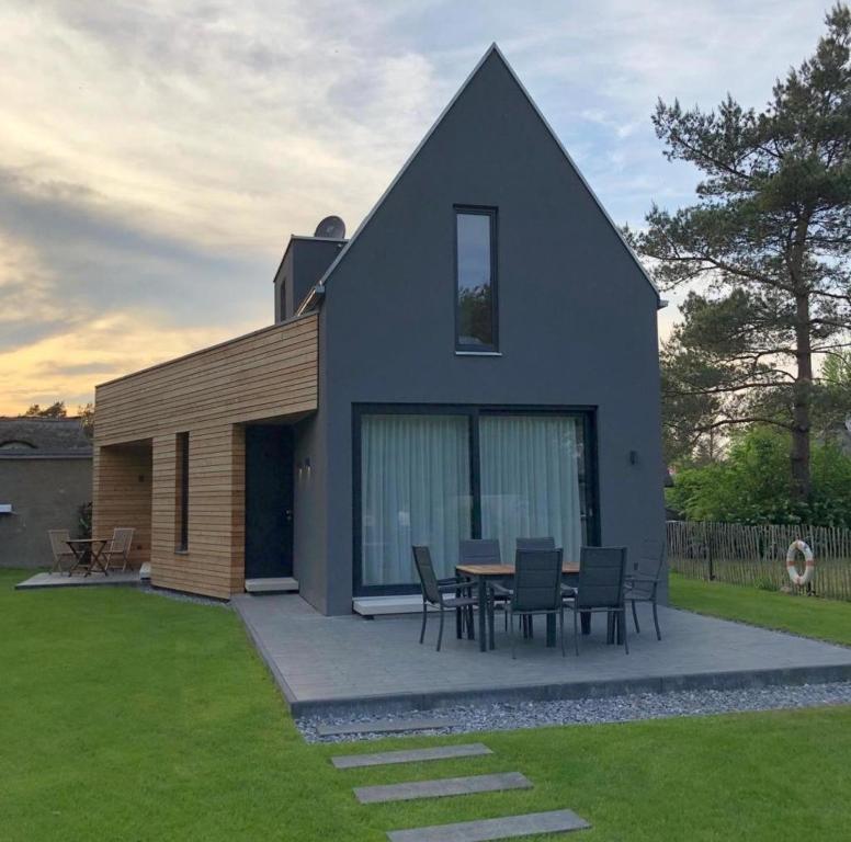 una casa con mesa y sillas en un patio en -"Strandhaus Friedrich"-, en Dierhagen