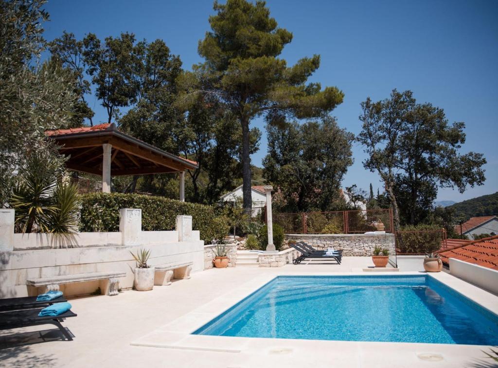 a swimming pool in the backyard of a house at Villa Nada - Unique and Artistic in Korčula
