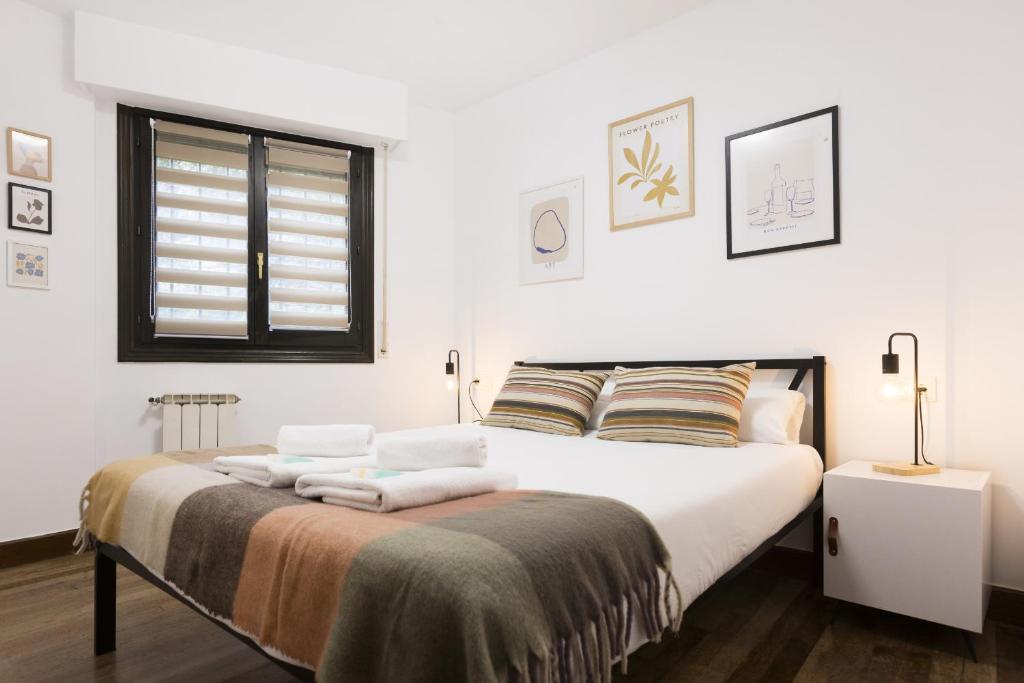 a bedroom with a bed with towels on it at Bordari by Smiling Rentals in Hondarribia