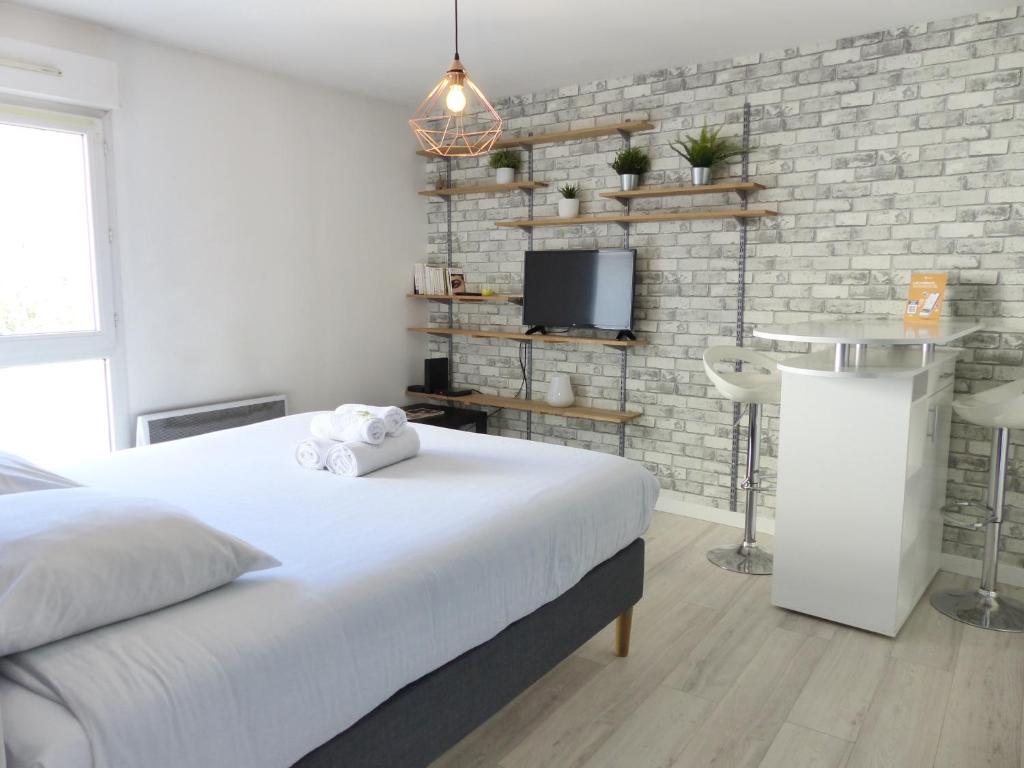 une chambre blanche avec un lit et une télévision dans l'établissement 3 Rois - Joli studio 2 pers, place de parking, à Nantes