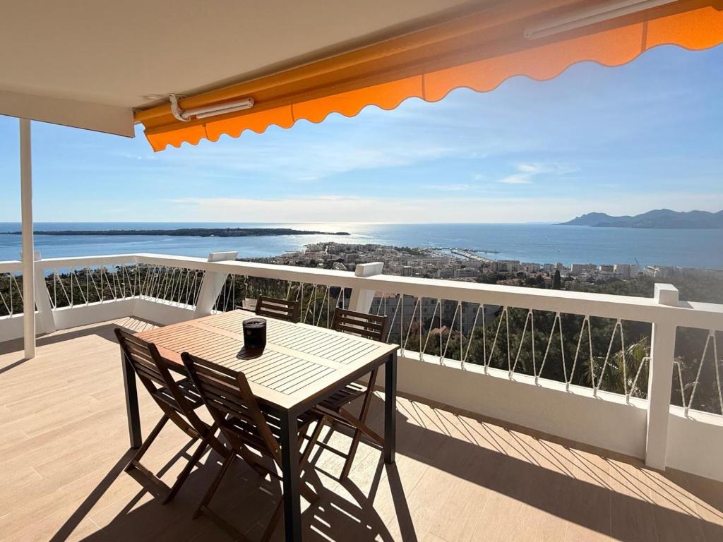 une table et des chaises sur un balcon avec vue sur l'océan dans l'établissement Panoramic Sea View Cannes renovated 3 bedrooms - Swimming Pool, à Cannes