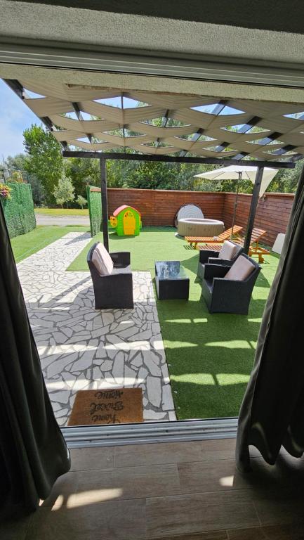 a view of a patio with chairs and a table at Sunrise Riverside House-Private Garden, Jacuzzi & BBQ in Čelarevo