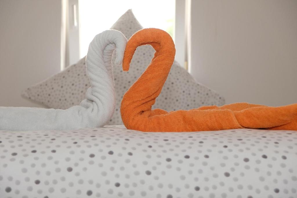 dos flamencos naranjas están sentados en una cama en Fewo Kiefer, en Bad Krozingen