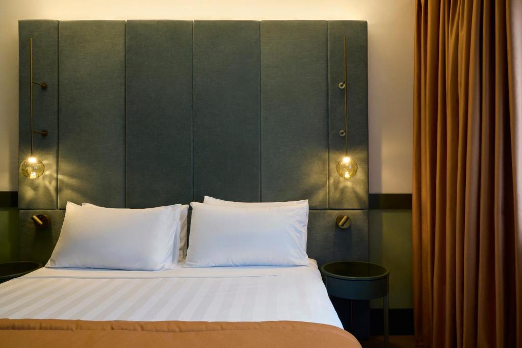 Postel nebo postele na pokoji v ubytování NEMI Hotel