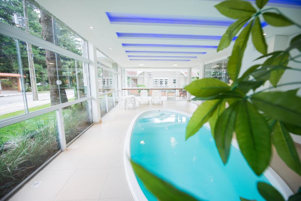 a swimming pool in a house with windows at Sky Premium Hotel Gramado - Ótima Localização in Gramado