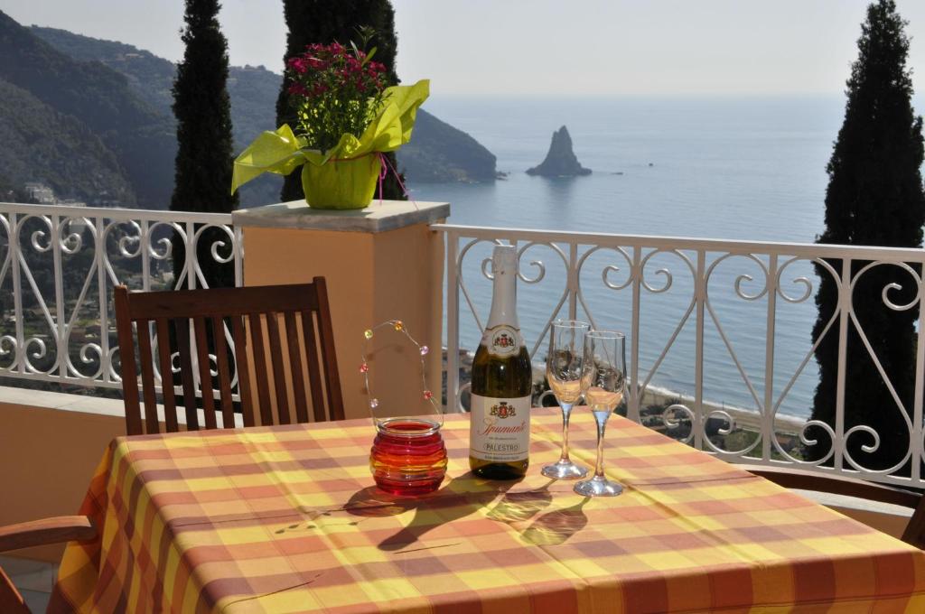 a table with a bottle of wine and glasses on a balcony at Stella's Apartments in Agios Gordios