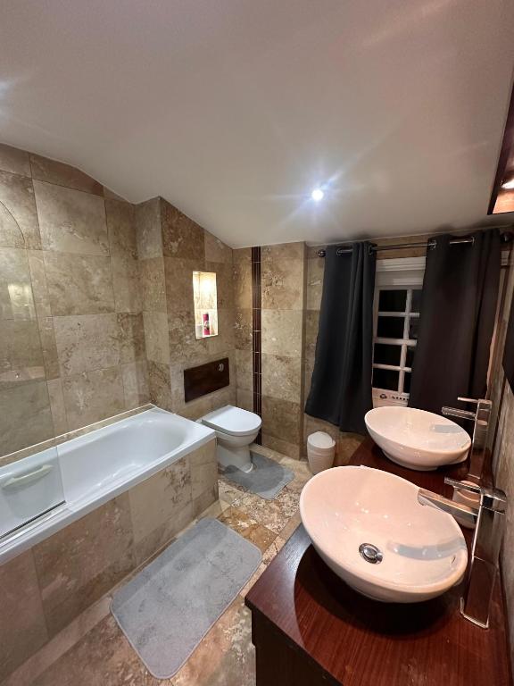a bathroom with two sinks and a tub and a toilet at London Bridge Room in London