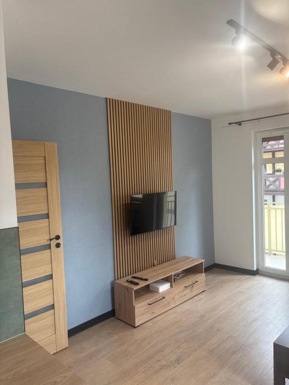 a living room with a tv on a wall at Plac Solny 4 Discreet&Comfort Głogów in Głogów