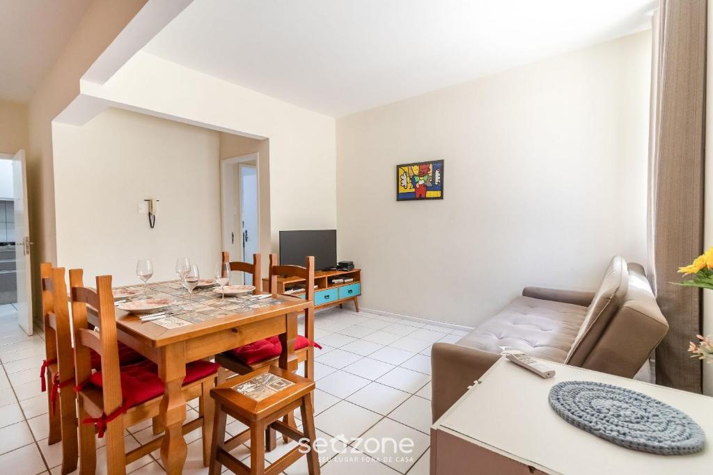 a dining room and living room with a table and a couch at Lindos Apartamentos no Centro de Floripa - CPN in Florianópolis