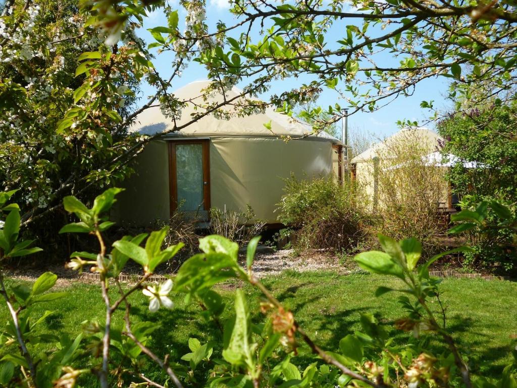 une petite caravane dans un jardin arboré dans l'établissement Les Yourtes du Perche, à Coulonges-sur-Sarthe