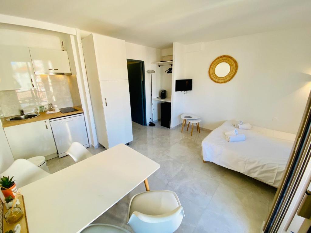 une chambre blanche avec un lit, une table et des chaises dans l'établissement Résidence Graziella Studio 424, à Juan-les-Pins