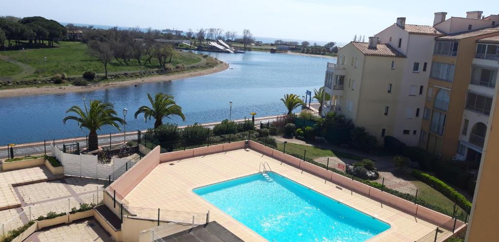 - une vue aérienne sur une piscine à côté d'une rivière dans l'établissement Le PANORAMIC, au Cap d'Agde