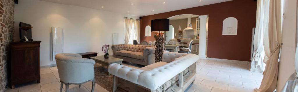 Coussac-BonnevalにあるLa Forge Maison de 110m2 en Limousinのソファとテーブルと椅子のあるリビングルーム