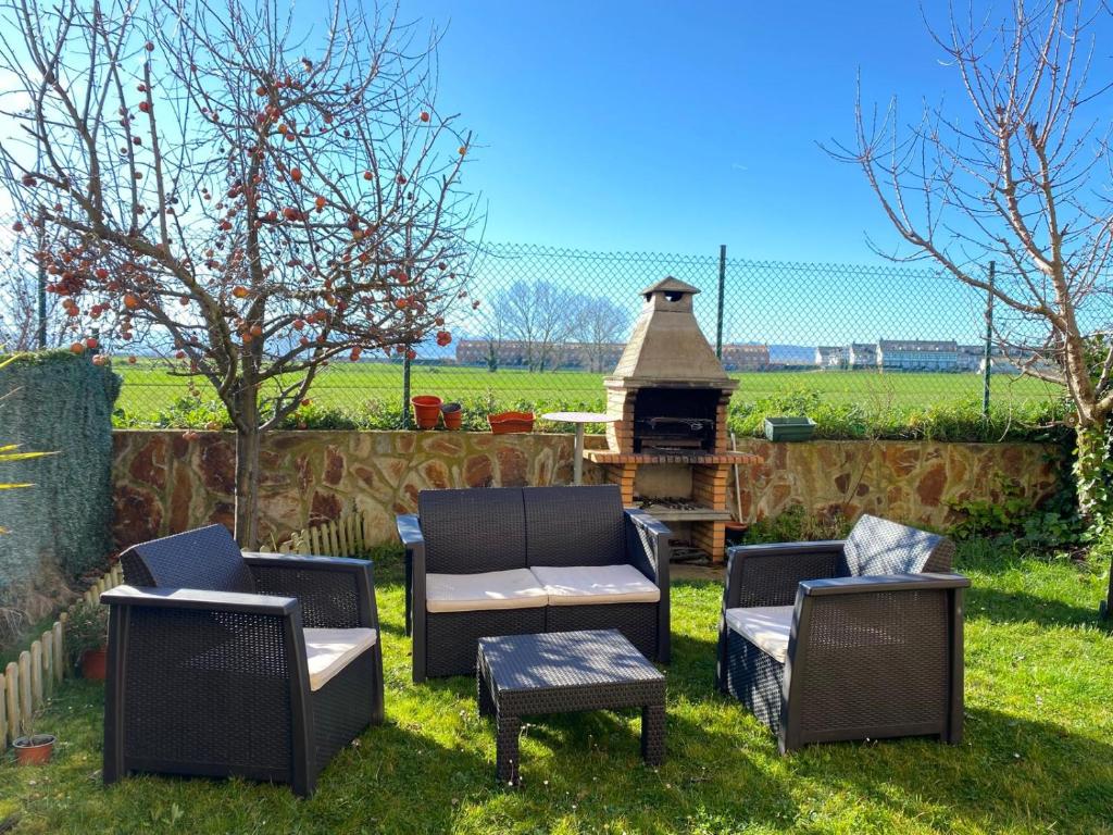 podwórze z dwoma krzesłami, stołem i grillem w obiekcie El Jardin de los Manantiales II w mieście Castañares de Rioja