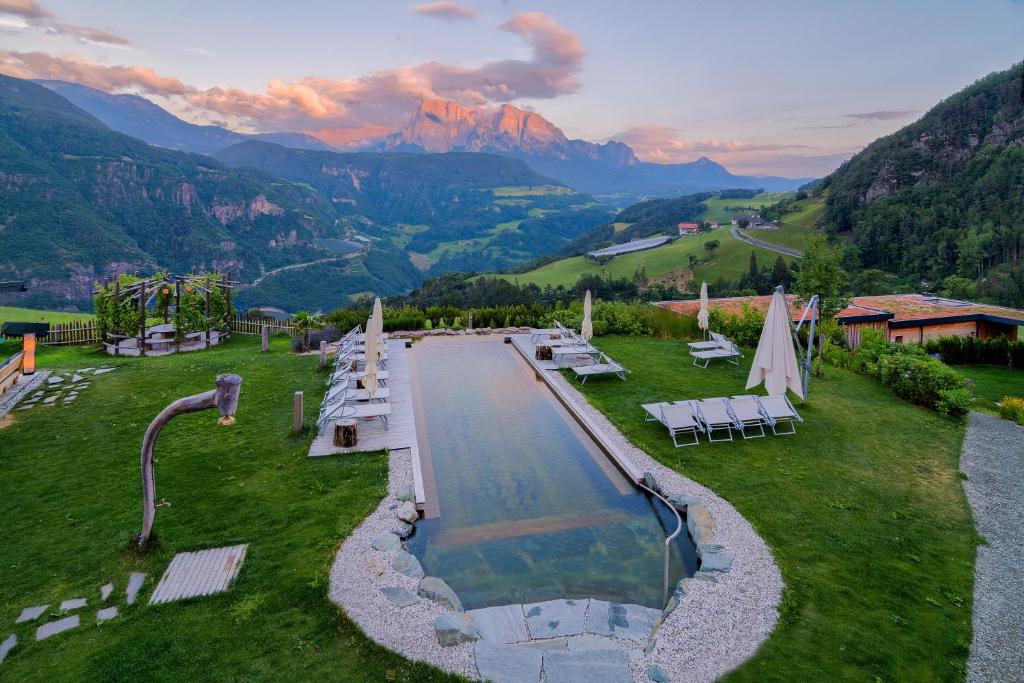 an aerial view of a pool with mountains in the background at Hotel-Chalet Pennhof in Barbiano