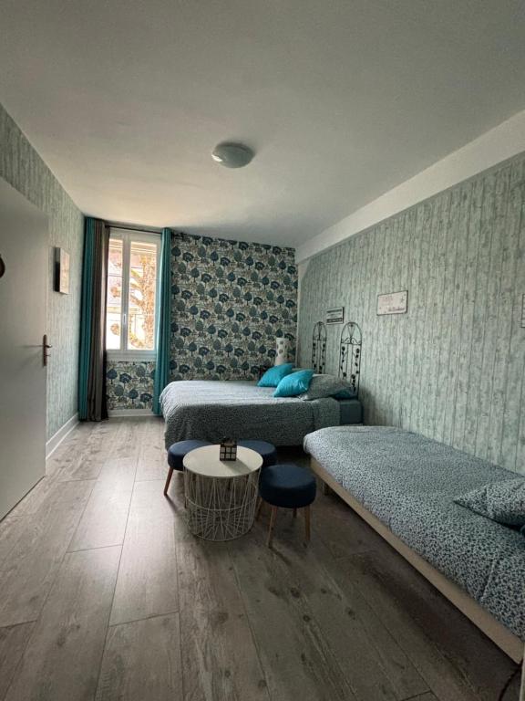 a bedroom with two beds and a table in it at LA MONGEARDIERE in Ay