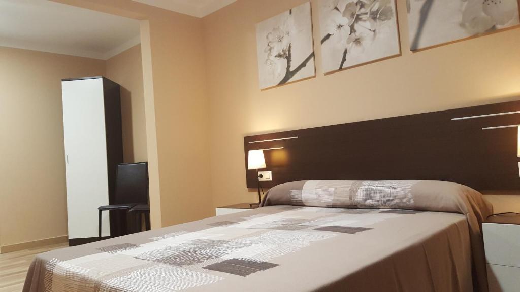 a bedroom with a large bed with a black headboard at Pensión Avenida in Vilafranca del Penedès