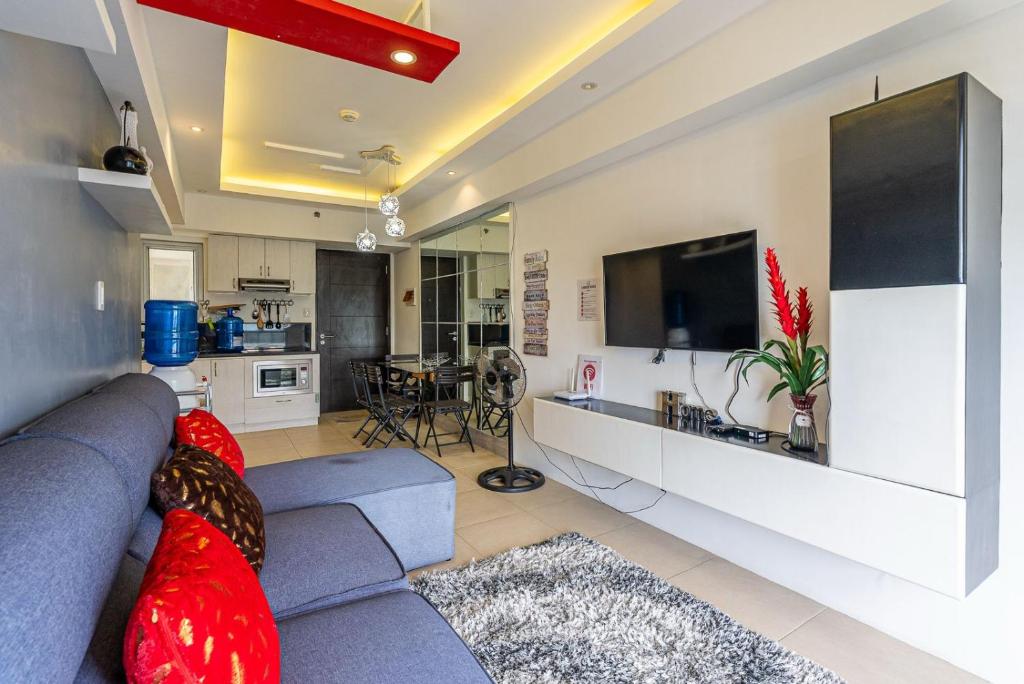 a living room with a blue couch and a kitchen at Avida Riala Tower 2, IT Park, New Fully Furnished in Cebu City