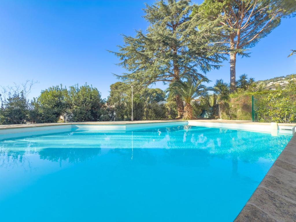 une grande piscine avec des arbres en arrière-plan dans l'établissement Le Cozy by Winsome Destination, à Cannes