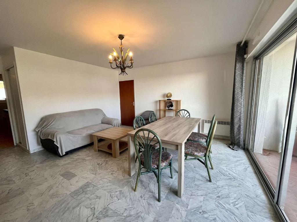 une salle à manger avec une table et un lit dans l'établissement Appartement 4 pièces avec parking, proche plage à Cavalaire - FR-1-226B-182, à Cavalaire-sur-Mer