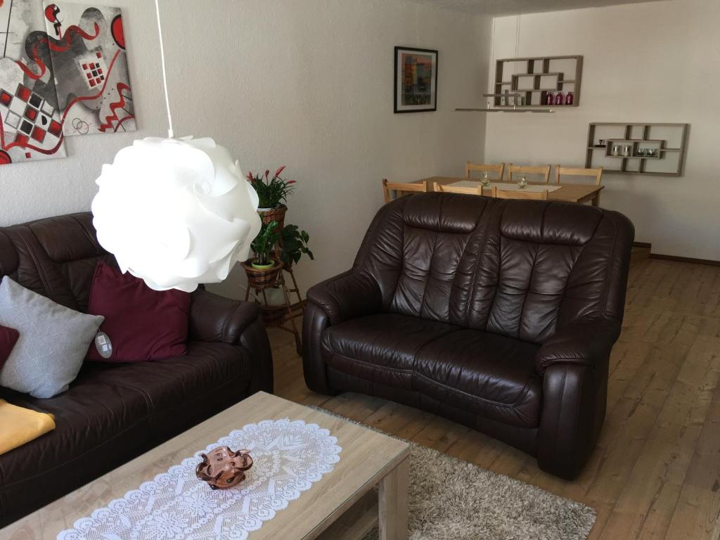 a living room with two leather couches and a table at frühsonnige Innenstadt-Vollkomfort-Wohnung in Zittau