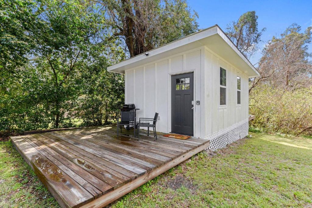 a small white shed with a chair on a wooden deck at Coastal Cabana Studio - Close to beach and Mississippi City in Gulfport