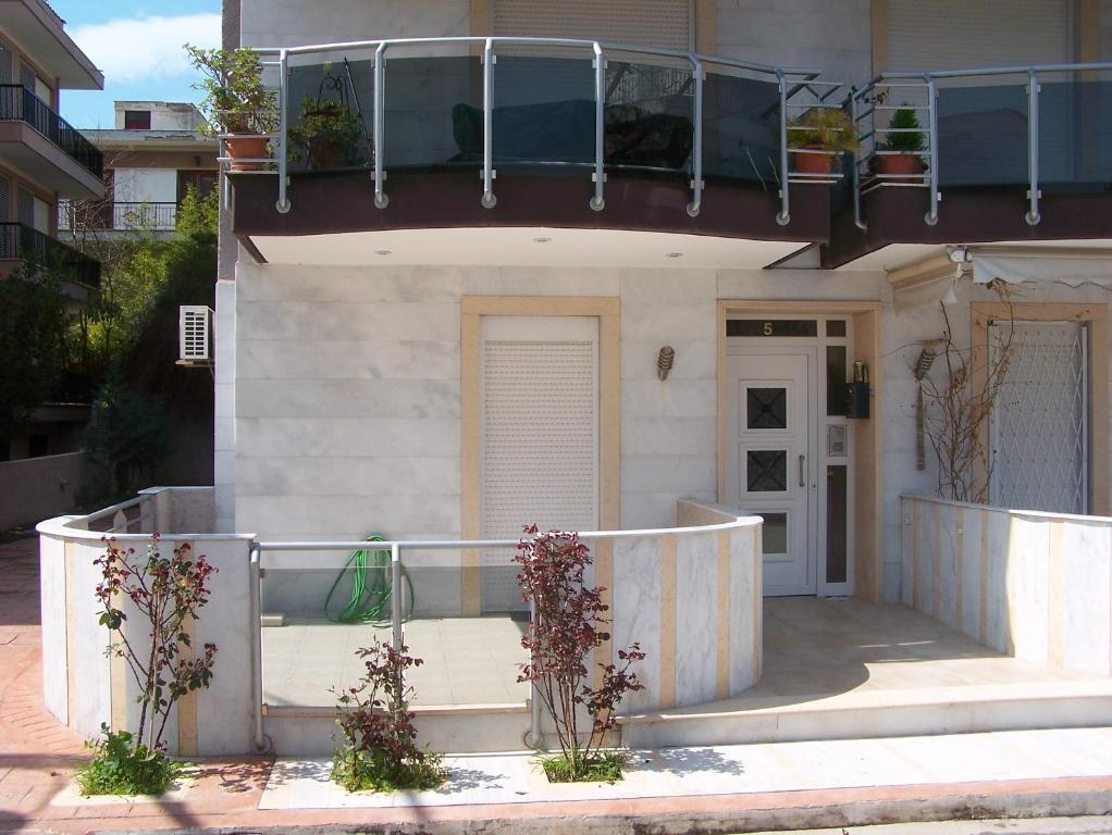a house with a balcony on top of it at Eirini Apartment in Nea Kalikratia