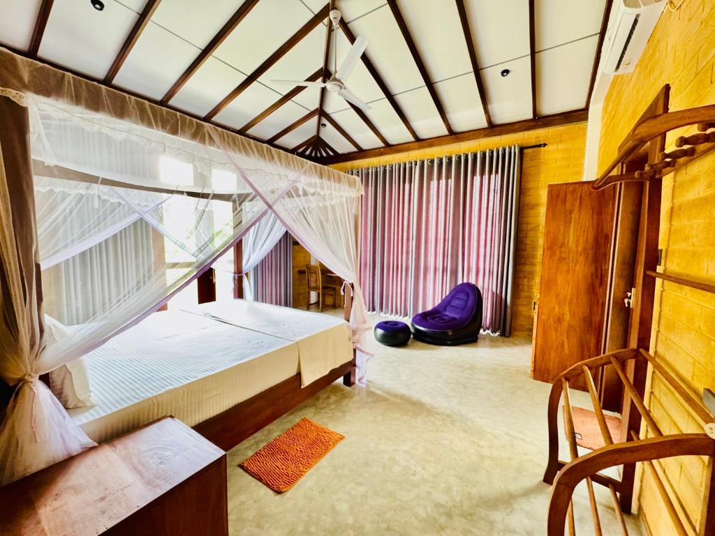 アハンガマにあるWalawwa Villa Kathaluwaのベッドルーム(天蓋付きベッド1台、椅子付)