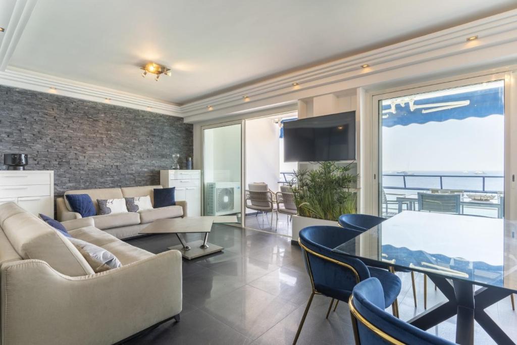 un salon avec un canapé, une table et des chaises dans l'établissement Spacious apartment with sea view in Antibes, à Antibes