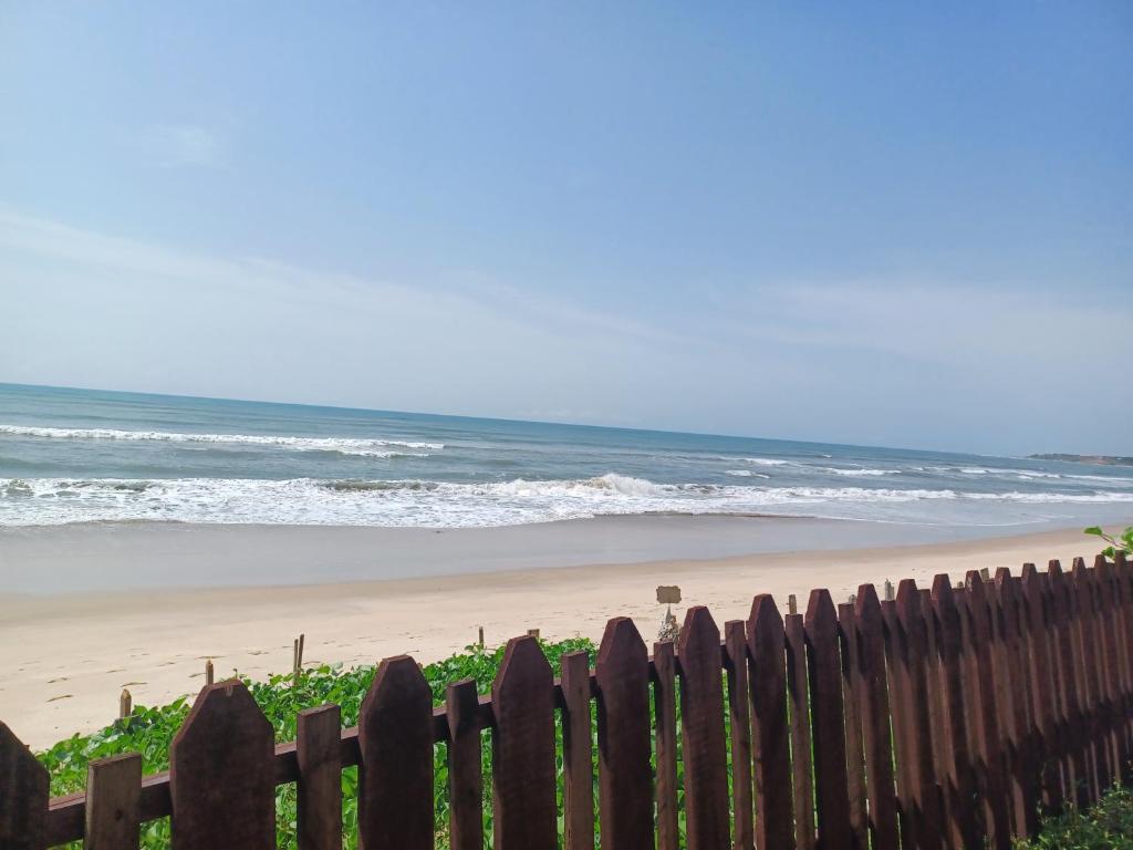 a wooden fence in front of a beach at Adinam's Beach Retreat in Nyanyanu