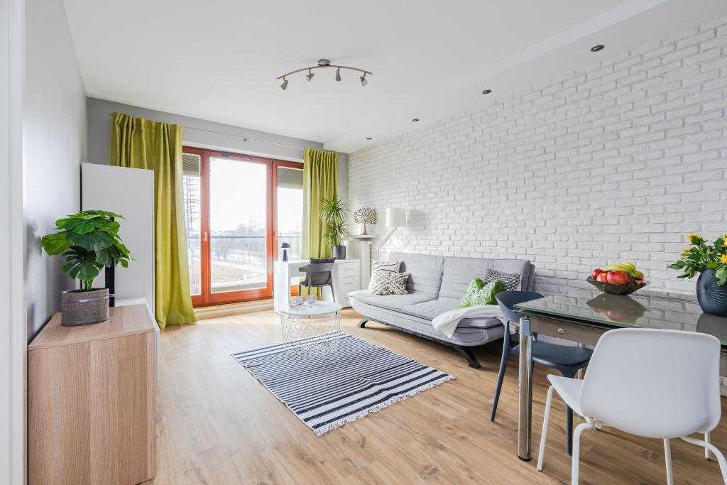 una sala de estar con un sofá y una mesa en Apartament Kiedacza, darmowy parking, en Varsovia
