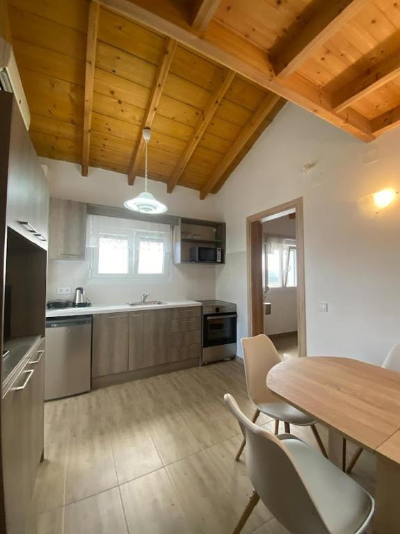 a kitchen with a table and chairs and a wooden ceiling at Theo apartment with Balcony in Marathias