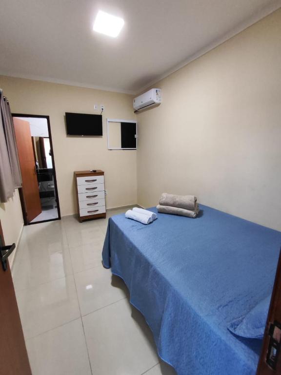a bedroom with a blue bed and a television at Pousada Pai&Filho in Piranhas