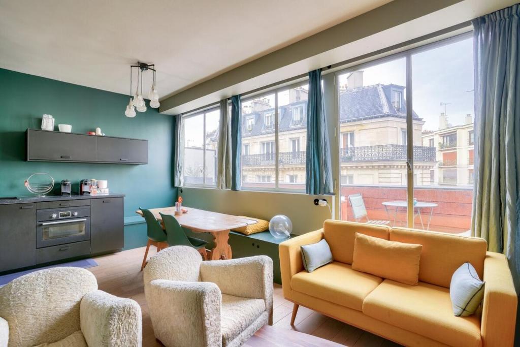 un salon avec un canapé, des chaises et une table dans l'établissement 1BR Flat with Balcony near the Eiffel Tower, à Paris