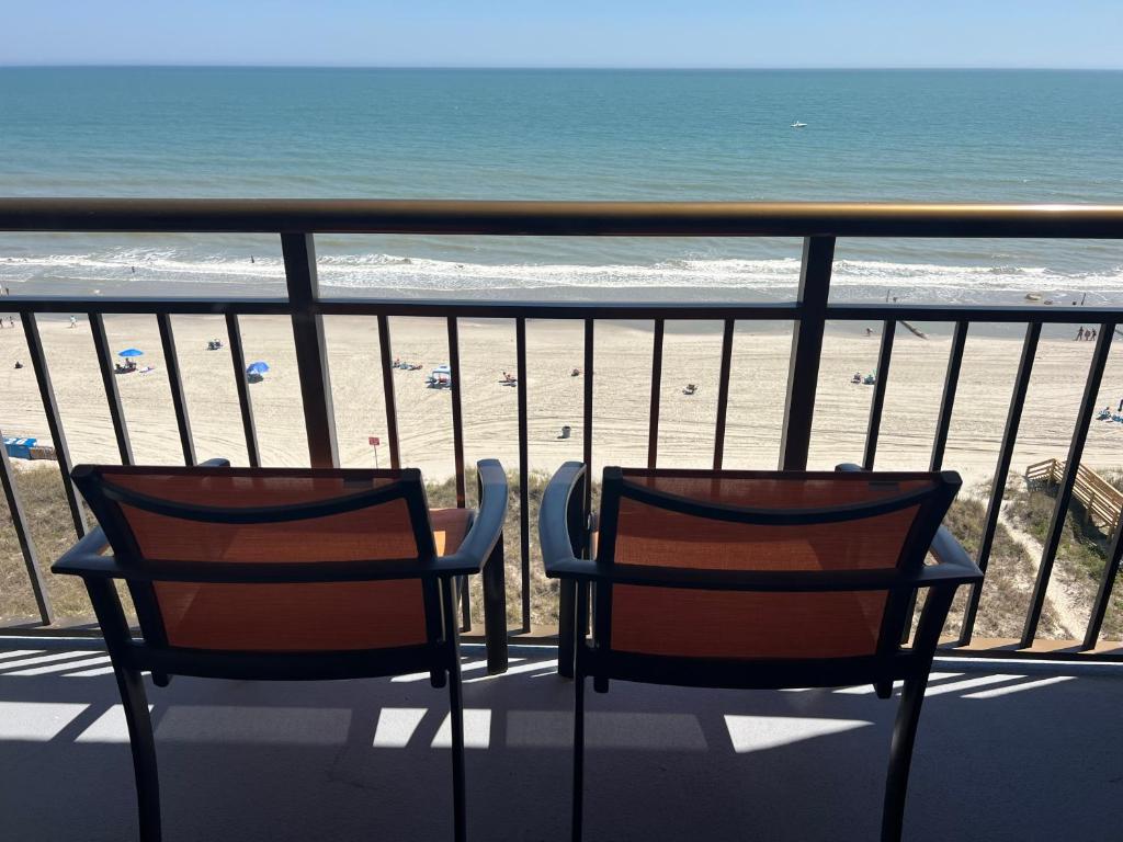 two chairs sitting on a balcony looking at the beach at Best Western Ocean Sands Beach Resort in Myrtle Beach